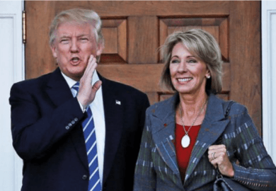 Donald Trump standing with Betsy DeVos