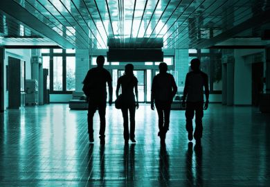 Silhouettes of students walking in university hallway