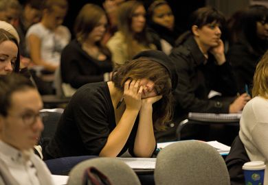 Woman sleeping in lecture theatre