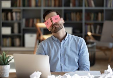 A business person sleeps with post-it notes of open eyes on his eyes
