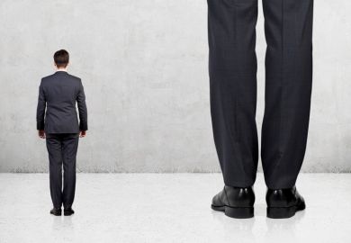 Small man standing next to giant Small man standing next to giant