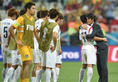 South Koreas football coach hugs one player South Koreas football coach hugs one player