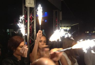 Women holding sparklers at party