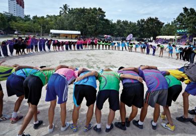 Sports team gathered in huddle at school sports event Sports team gathered in huddle at school sports event