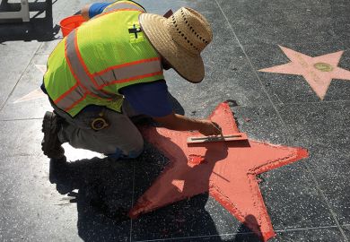 A worker repairs a star on the Hollywood Walk of Fame A worker repairs a star on the Hollywood Walk of Fame