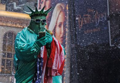 A man dressed up as the Statue of Liberty holding a mobile A man dressed up as the Statue of Liberty holding a mobile