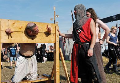 A man in stocks at a modern-day fete A man in stocks at a modern-day fete