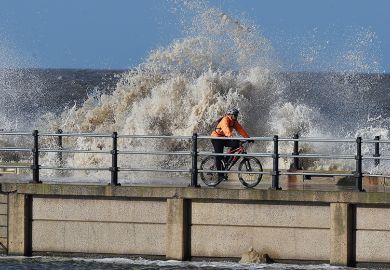 Man riding bicycle on stormy pier Man riding bicycle on stormy pier