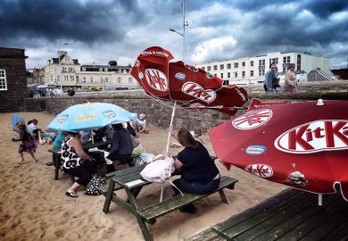 Holidaymakers brave the weather and shelter under an umbrella as another turns inside out in the wind, on the beach in Weston-super-Mare, England. To illustrate a summer of ‘chaos’ being predicted as mass job cuts close the academic year. Holidaymakers brave the weather and shelter under an umbrella as another turns inside out in the wind, on the beach in Weston-super-Mare, England. To illustrate a summer of ‘chaos’ being predicted as mass job cuts close the academic year.