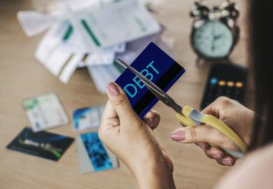 Scissor cut through a credit card marked "debt"