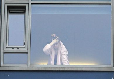 A student at the window in a university halls of residence