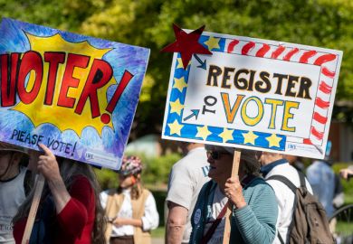People with signs encouraging people to vote People with signs encouraging people to vote