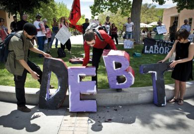 Students holding letters spelling 'Debt', University of New Mexico