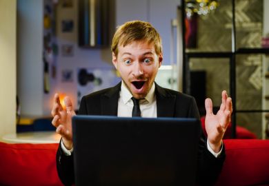 Surprised happy businessman wearing black suit using laptop amazed with open mouth for surprise