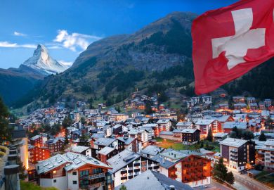 Swiss town with flag of Switzerland and Swiss Alps (Matterhorn) in background