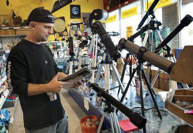 man in telescope shop