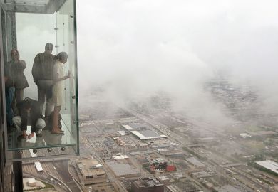 Visitors stand out on the Ledge, a glass cube that juts out from the 103rd floor Skydeck of the Sears Tower, Chicago