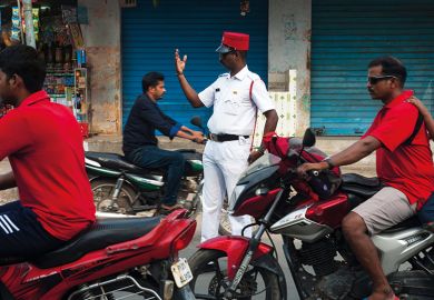 Policeman directing traffic on a street at Puducherry, India