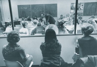 Three visiting teachers watch through a one-way window along the wall of a special demonstration classroom Three visiting teachers watch through a one-way window along the wall of a special demonstration classroom