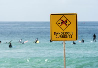 Dangerous currents warning sign on beach, Australia Dangerous currents warning sign on beach, Australia