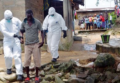 Nurses escort a man infected with the Ebola virus to a hospital
