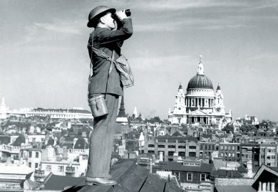 Man standing on a roof using binoculars