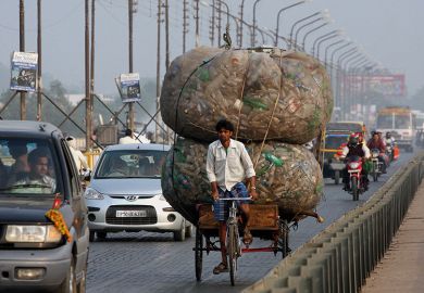 An Indian rickshaw puller transports discarded plastic bottles in Allahabad