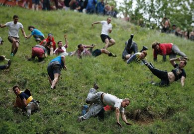 Competitors tumble down Coopers Hill in pursuit of a round Double Gloucester cheese during an annual cheese rolling competition