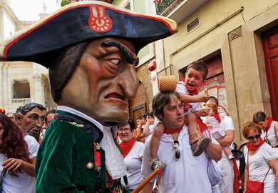 A child react (R) as Caravinagre 'Vinegar face' kiliki (C) approaches during the Comparsa de Gigantes y Cabezudos, or Giants and Big Heads parade on the third day of the San Fermin Running of the Bulls festival on July 8, 2016 in Pamplona, Spain. 