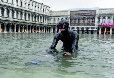 Scuba diver wading in floodwater, Saint Mark's Square, Venice