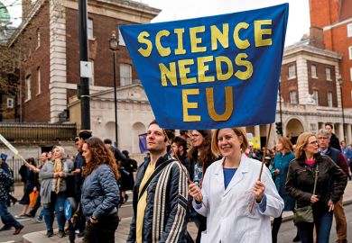 A protester holds a "Science needs EU" banner on a march and rally organised by the pro-European People's Vote campaign for a second EU referendum in Parliament Square, central London on March 23, 2019