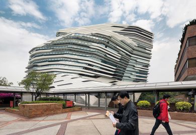 People walking past Jockey Club Innovation Tower, Hong Kong, China. Part of Hong Kong Polytechnic University