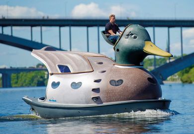 man driving giant duck on river