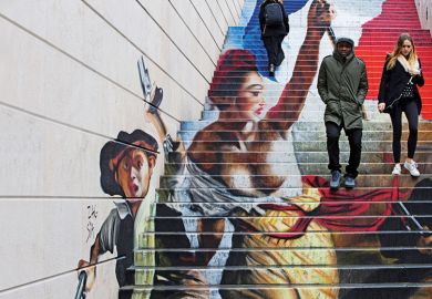 A couple walking down steps with graffiti in the background