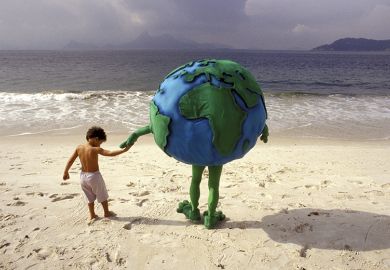 Little boy holding hands with person dressed as planet Earth