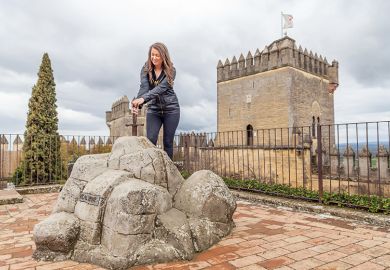 Woman pretends to pull King Arthur’s sword out of its stone