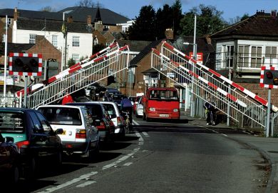 Barriers lifting at level crossing and waiting traffic streaming through Barriers lifting at level crossing and waiting traffic streaming through
