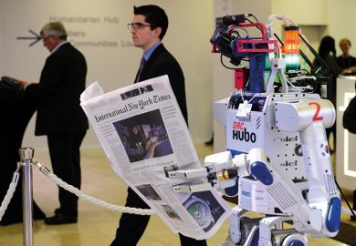 A robot holds a newspaper during a demonstration at the World Economic Forum (WEF) annual meeting in Davos