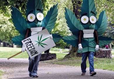 Two people dressed as cannabis leaves