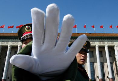 A Chinese paramilitary policeman gestures towards a photographer to stop taking pictures while standing guard at the Great Hall of the People, Beijing A Chinese paramilitary policeman gestures towards a photographer to stop taking pictures while standing guard at the Great Hall of the People, Beijing