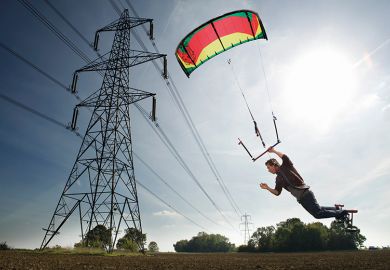 Man paragliding near power lines