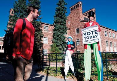 Person on stilts encourages students on the University of Colorado campus to vote