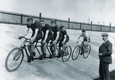 A four-man cycling tandem team in training with the 'chase and pacemaker' whilst being timed on the stopwatch.