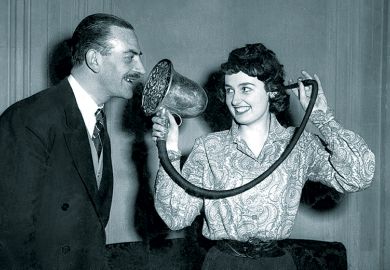 Woman demonstrating a Chase silver ear trumpet, made in 1880 and used by Queen Victoria, at the 'Escape From Deafness' exhibition in Park Lane House, Park Lane, London.