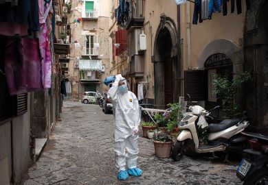 A healthcare worker wearing a protective suit walks through the Quartieri Spagnoli (Spanish Quarters) to screen people for coronavirus (Covid-19) during the pandemic. Italy
