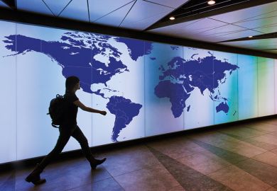 Person walking past map of the world