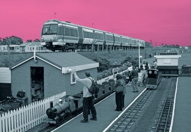 Miniature railway next to real train