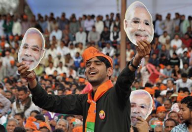 man holding face mask_three face masks_crowd_orange hat