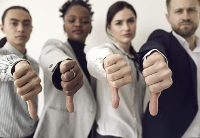 Four people giving a thumbs-down signal
