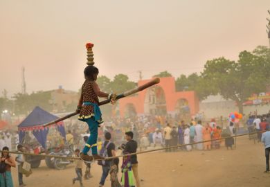 An Indian girl walks on a tightrope